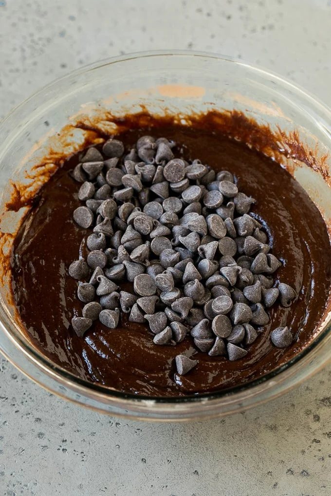 Chocolate brownie batter with chocolate chips in it.