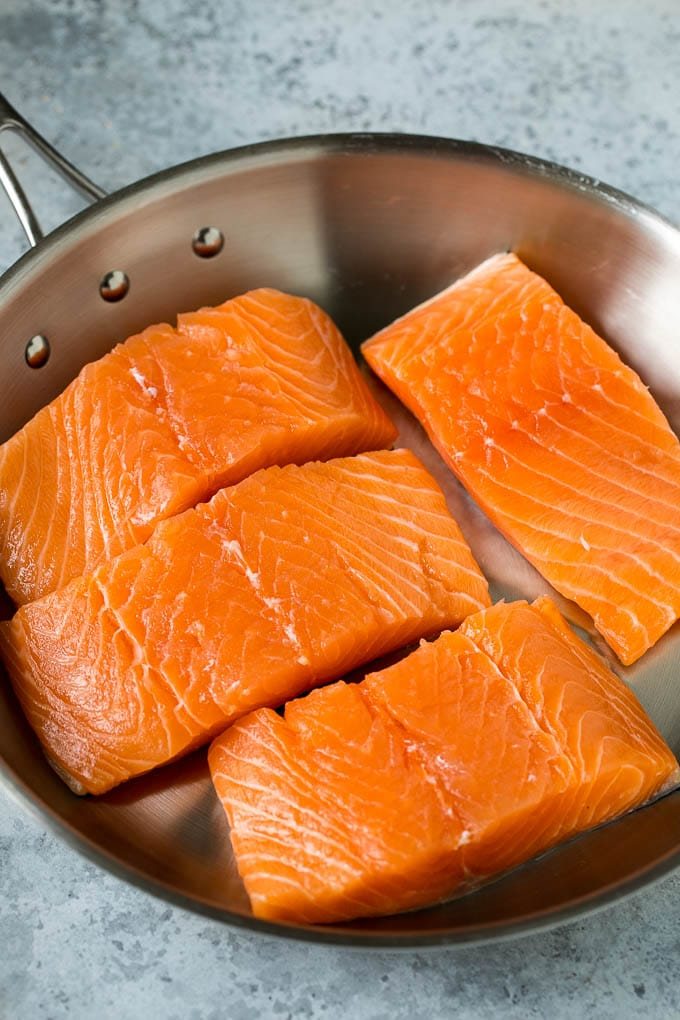 Raw salmon fillets in a pan.
