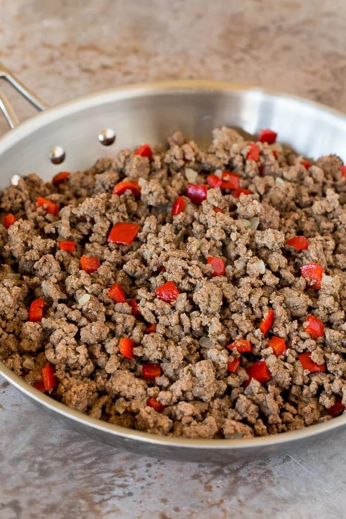 Ground beef and bell peppers in a skillet.