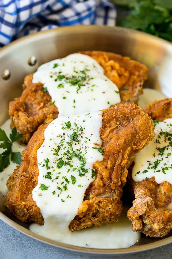 Fried pork chops topped with silky gravy and parsley.