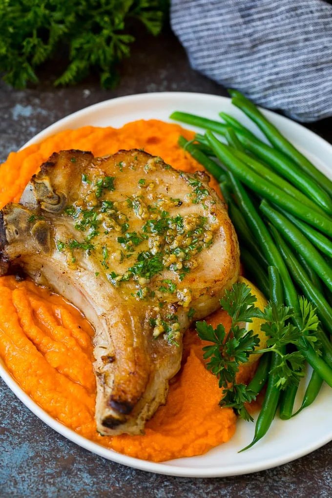 Meat served with sweet potatoes and green beans.