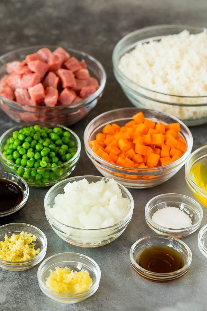 Bowls of ingredients including rice, pork, vegetables and seasonings.