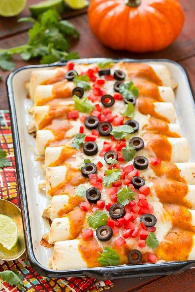 A tray of pumpkin enchiladas with a silky, savory pumpkin sauce.
