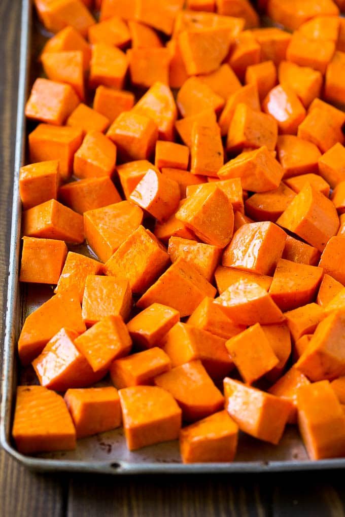Raw diced sweet potatoes on a sheet pan, ready to go into the oven.