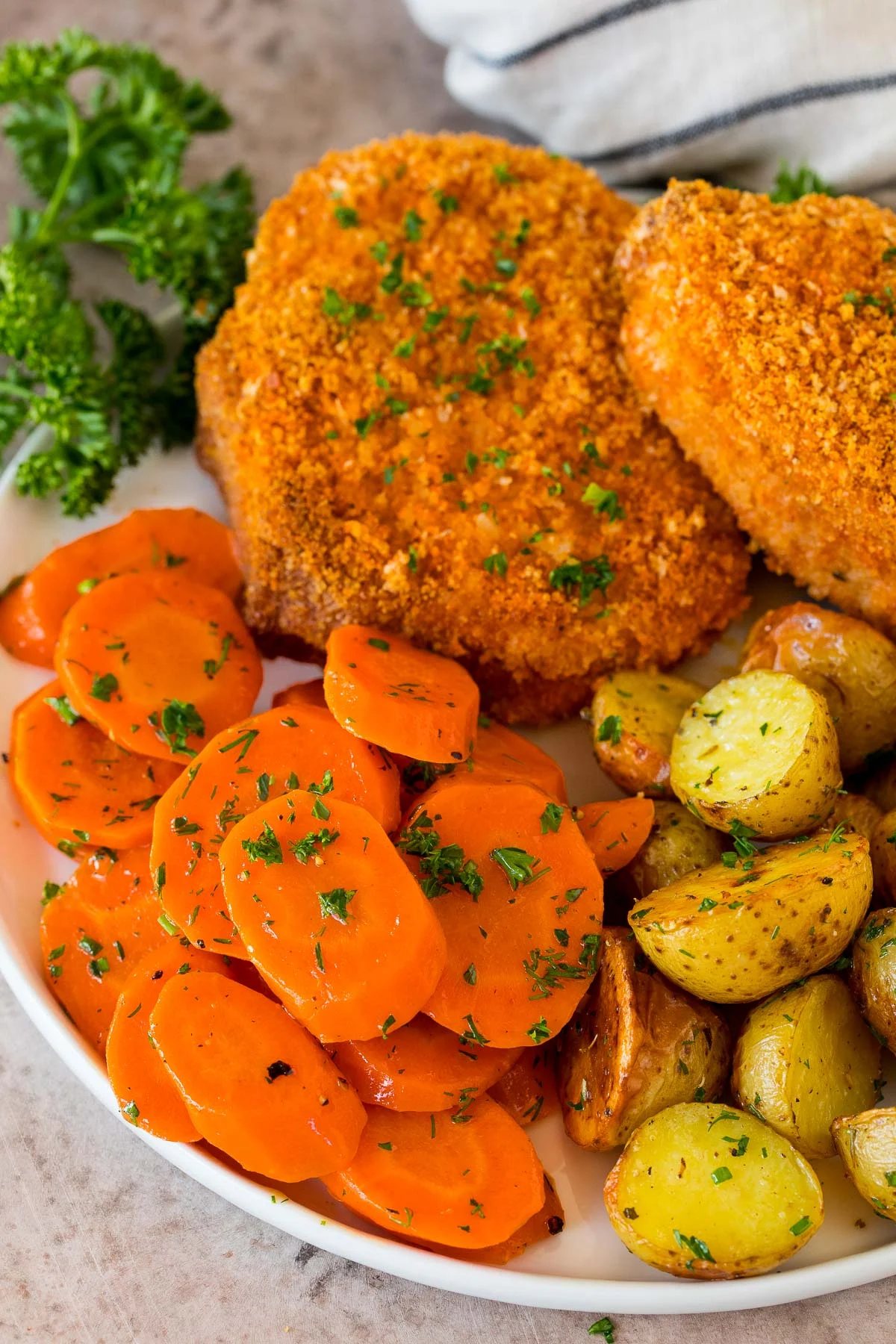 Sauteed carrots on a plate with pork chops, carrots and potatoes.