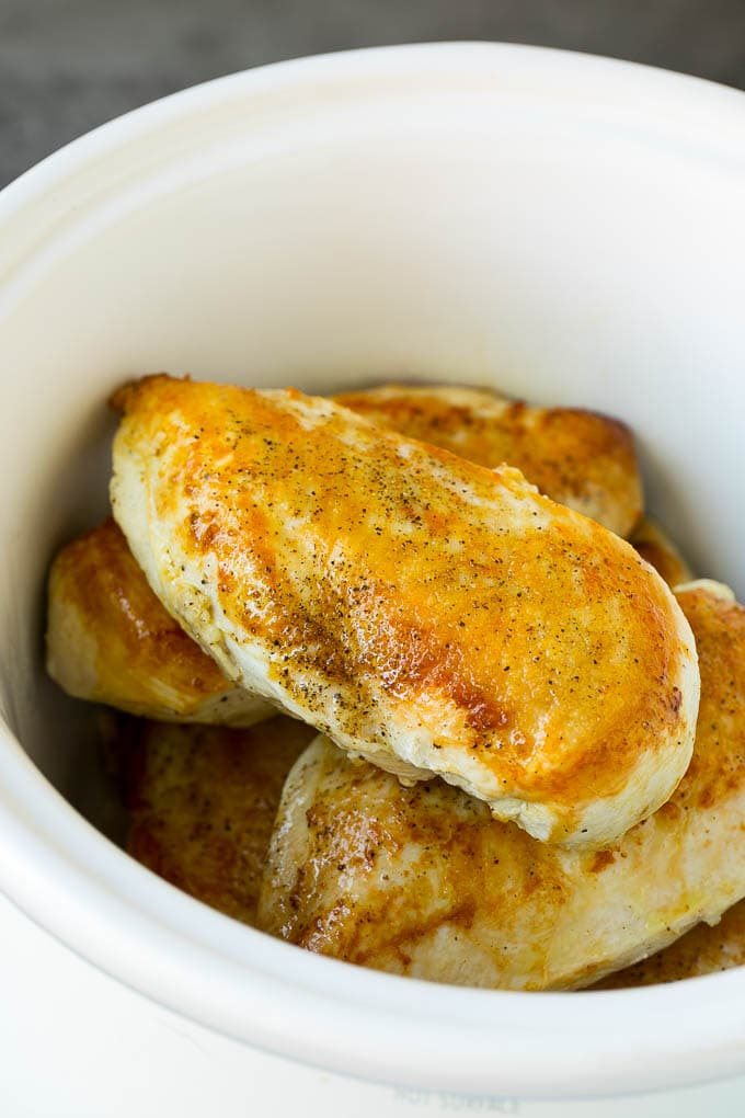 Seared chicken breasts in a crock pot.