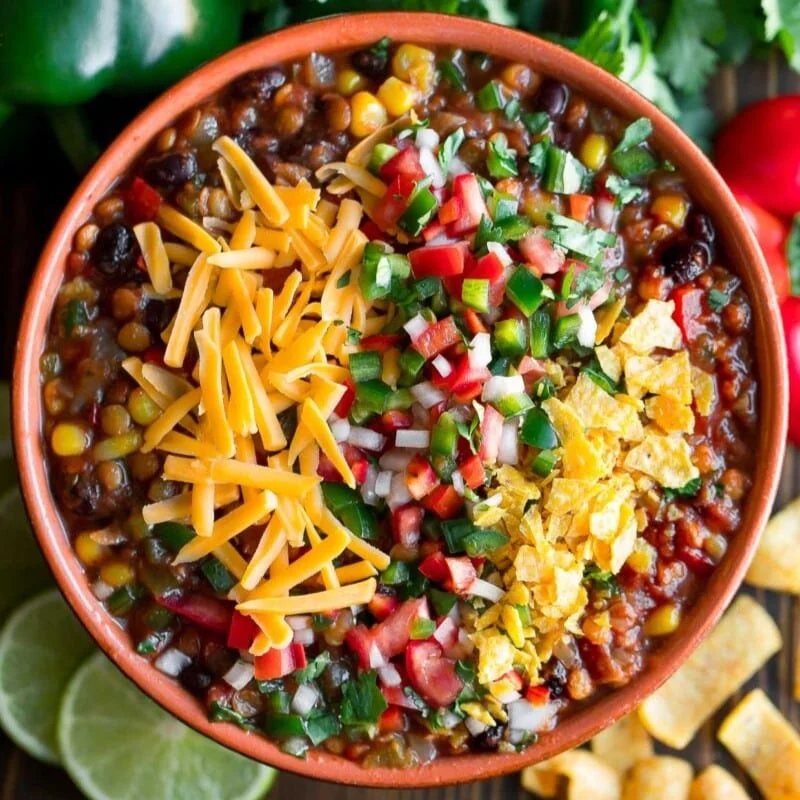 An image of lentil taco chili in a bowl with cheese on top.