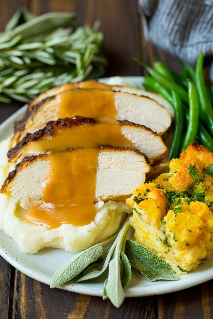 Sliced slow cooker turkey breast served with stuffing and green beans.