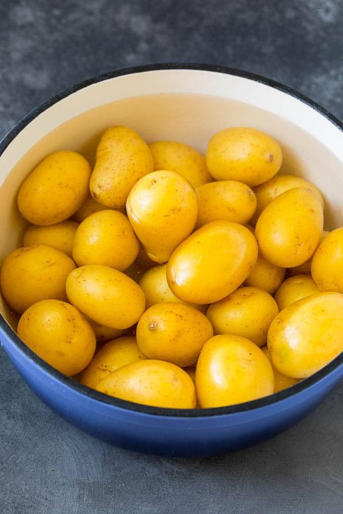 Baby potatoes in a pot of water.