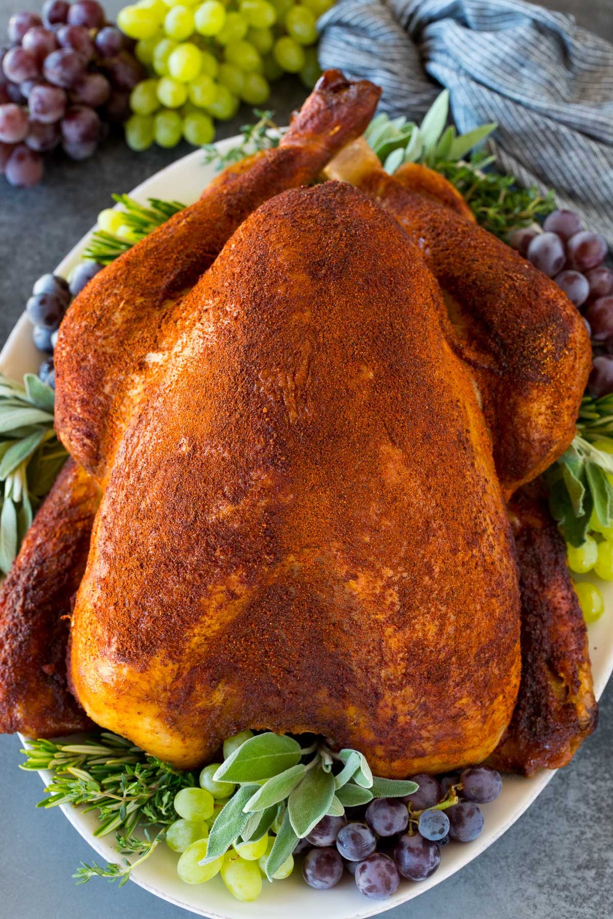 A cooked smoked turkey on a serving platter.