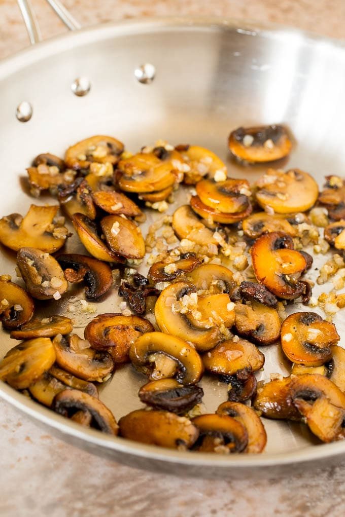 Sauteed mushrooms and shallots in a skillet.