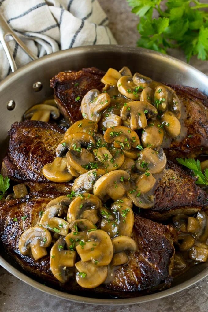 Mushroom steak sauce served over New York strip steaks.
