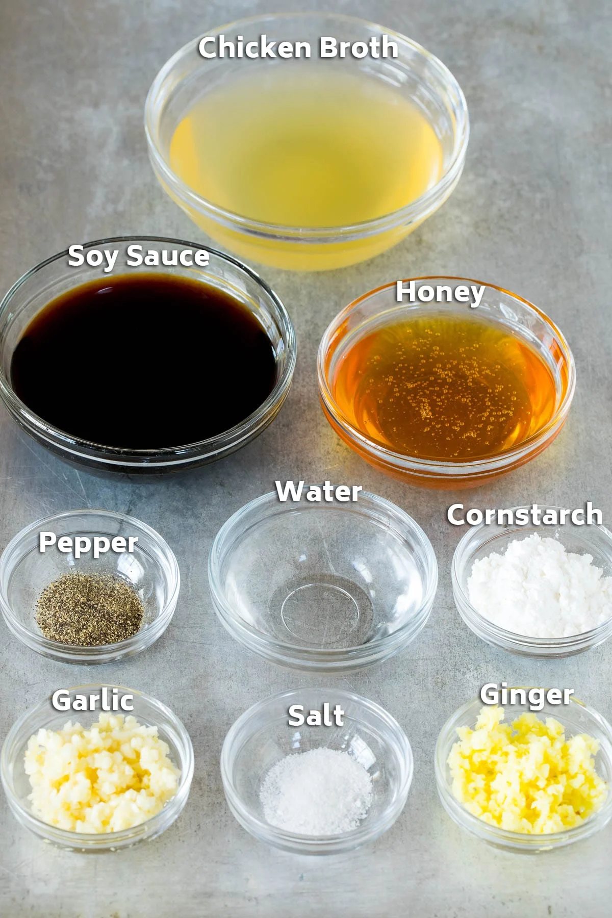Bowls of ingredients including chicken broth, soy sauce, ginger, garlic and cornstarch.