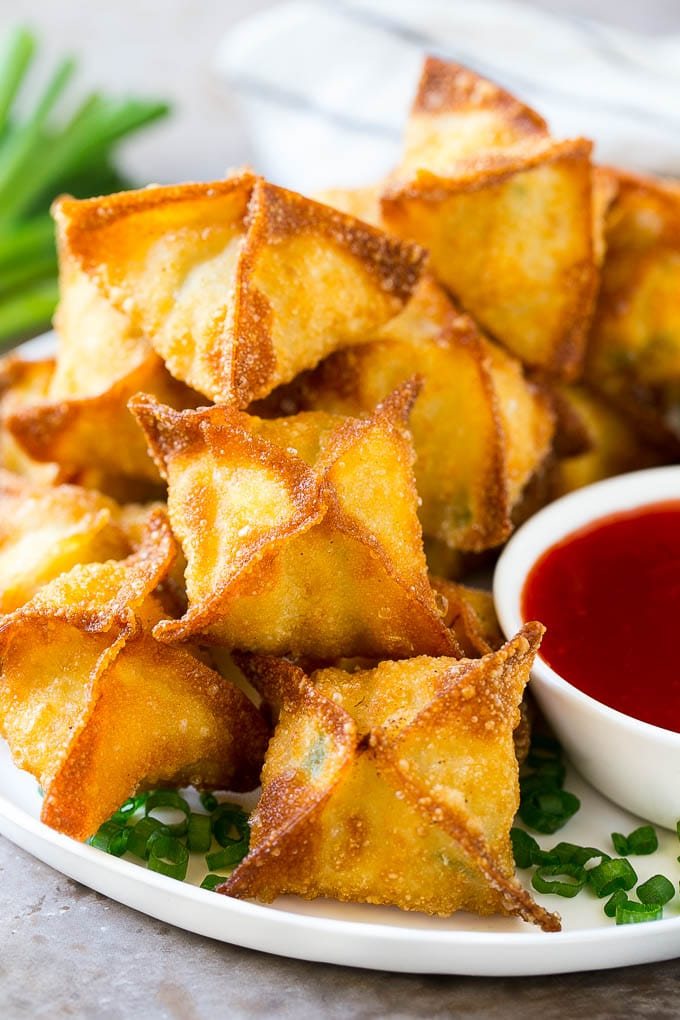 A pile of crab rangoon wontons filled with a silky crab mixture.