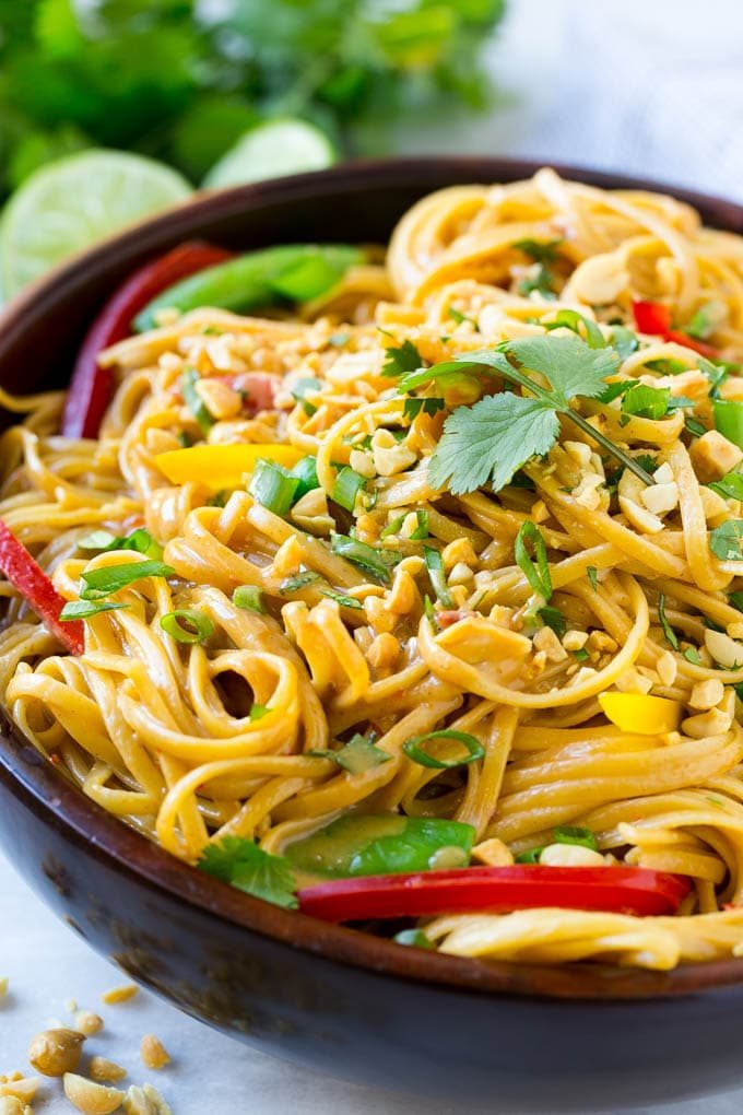 A bowl of Thai peanut noodles made with kitchen-made peanut sauce, fresh vegetables and chopped peanuts.