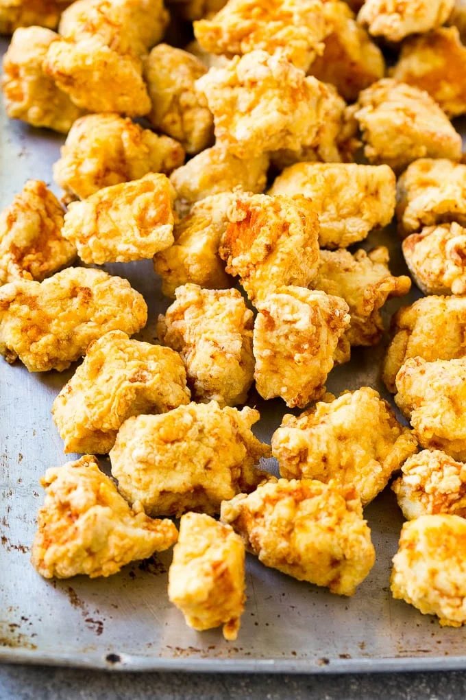 Fried chicken breast pieces on a sheet pan.