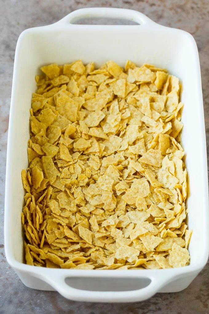 Crushed tortilla chips in a casserole dish.