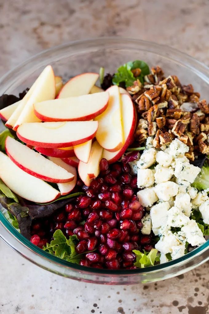 Lettuce topped with apples, blue cheese, pecans and pomegranate seeds.