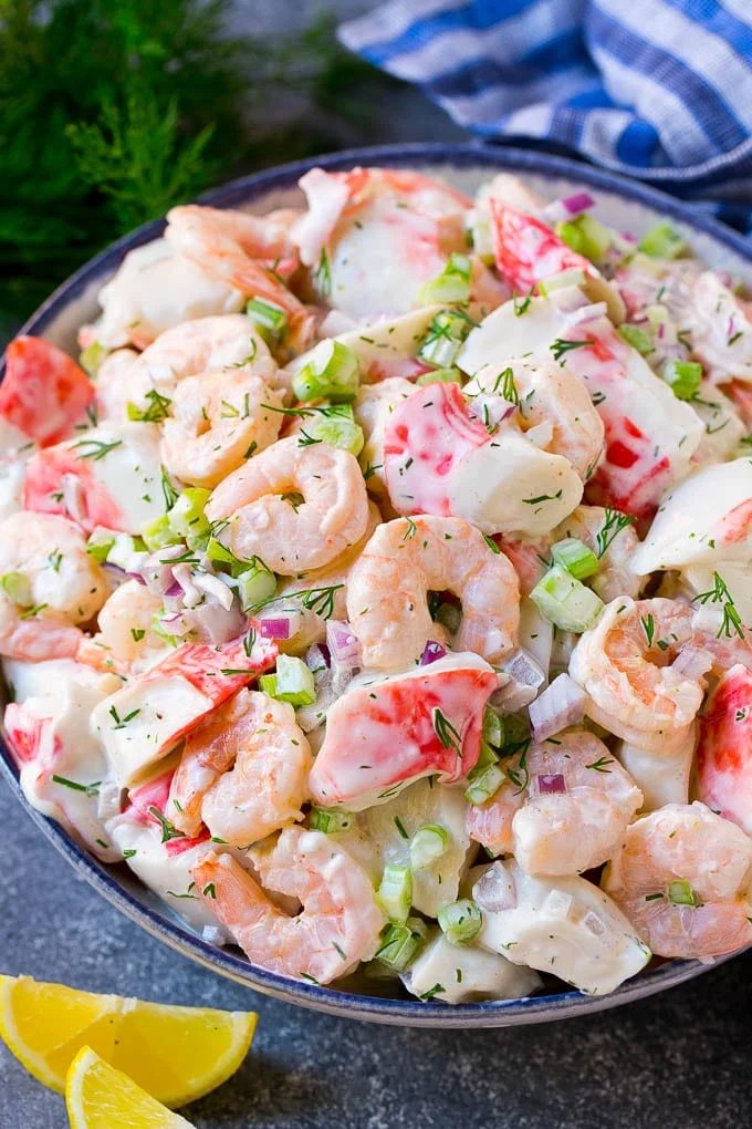 A serving bowl of seafood salad made with shrimp and imitation crab in a silky dill dressing.