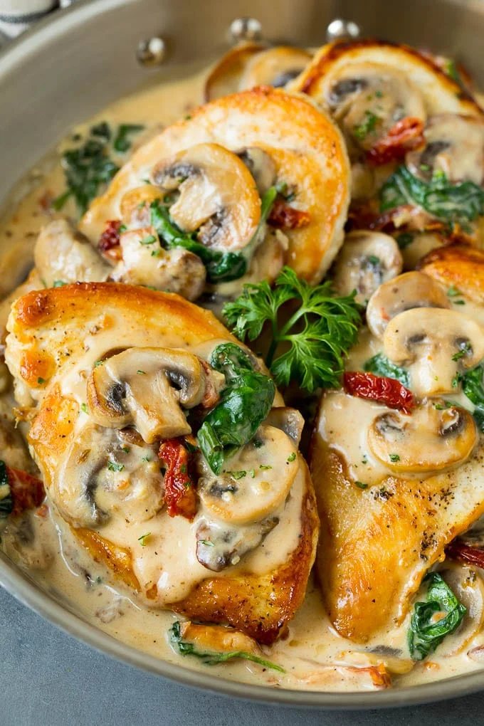 A pan of Tuscan chicken topped with silky mushroom and spinach sauce.