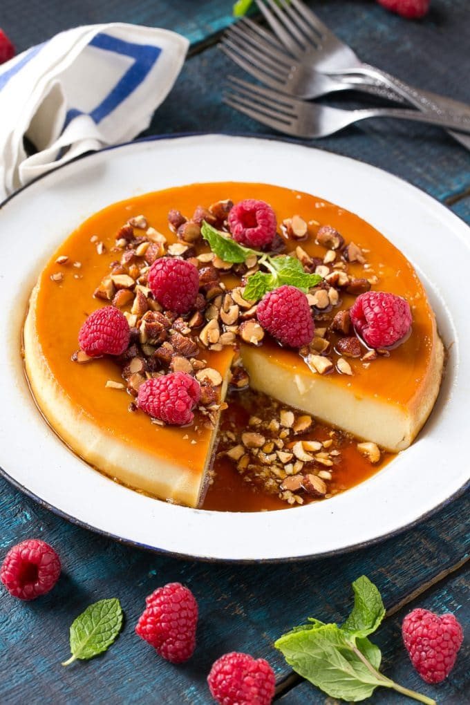 This rich and silky flan is flavored with vanilla and almonds and is finished off with chopped honey roasted almonds and raspberries.