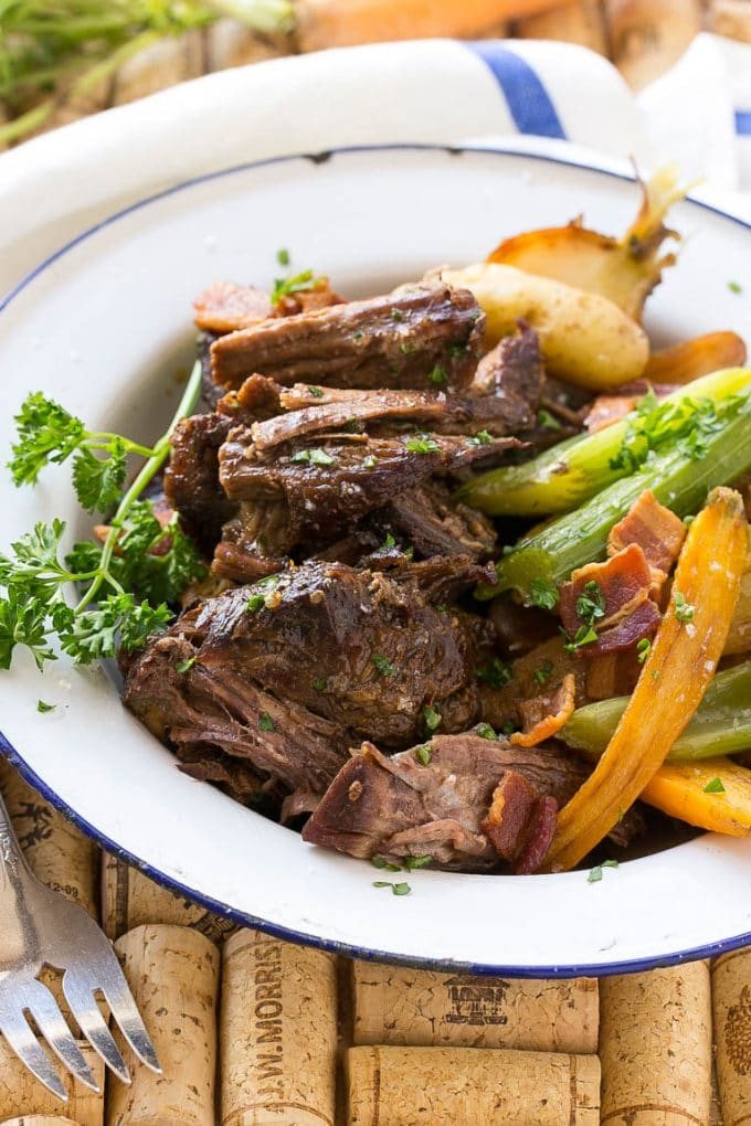A plate of shredded Yankee pot roast with vegetables and bacon.
