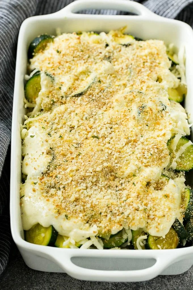 Zucchini gratin with layers of cheese, sauce and breadcrumbs, ready to go into the oven.