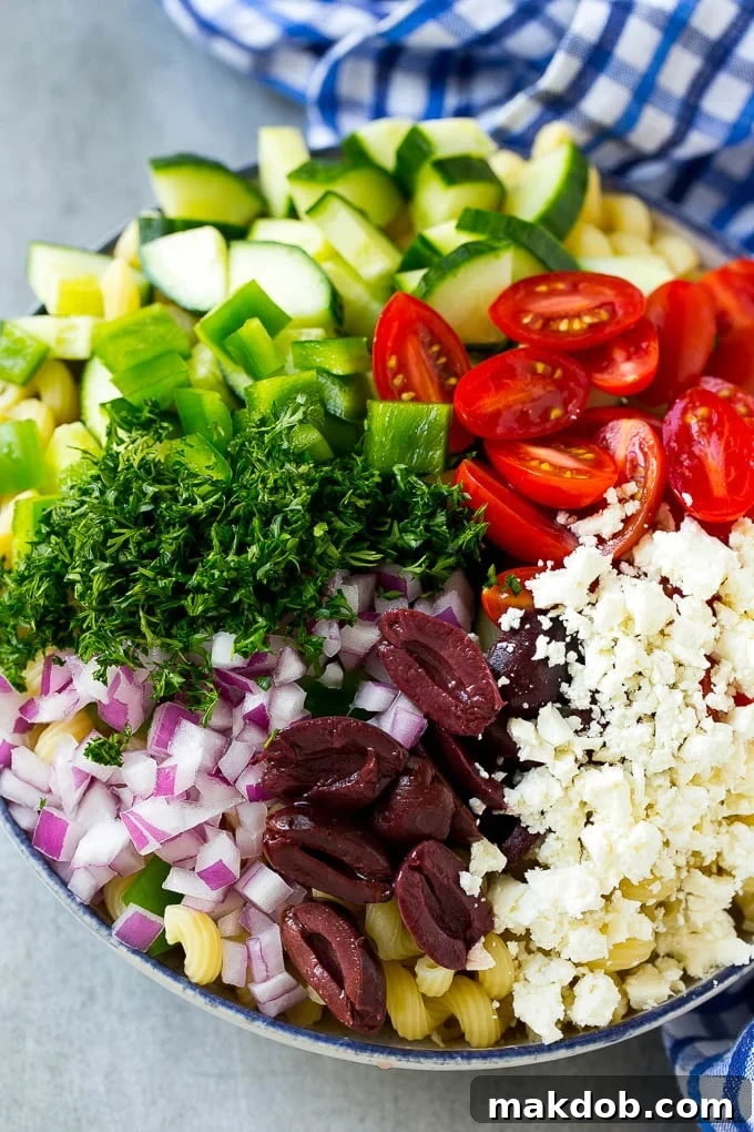 Cherry tomatoes, bell pepper, olives, feta, herbs and cucumbers over pasta.