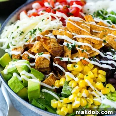 A bowl of BBQ chicken salad topped with a drizzle of ranch dressing, ready for serving.