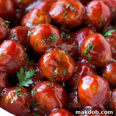 A crock pot full of cranberry meatballs, ready for serving.