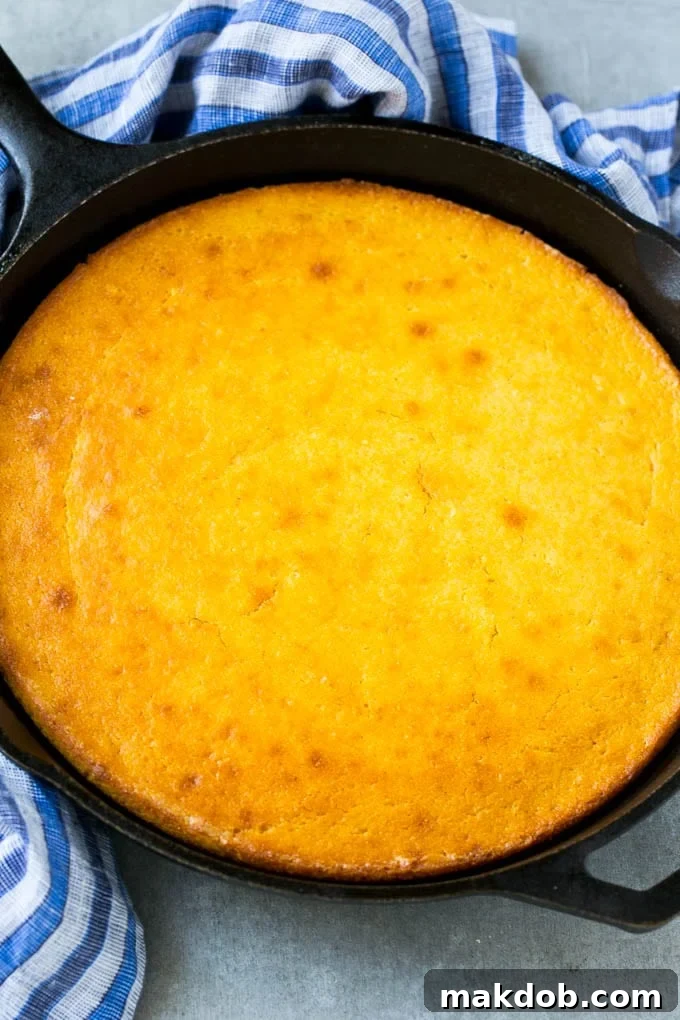 Homemade Cast Iron Cornbread with Honey A golden-brown honey cornbread baked to perfection in a classic cast iron pan, ready for slicing.