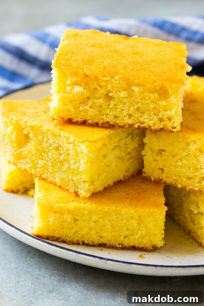 Easy Homemade Cornbread Squares A rustic plate presenting neatly cut squares of golden cornbread, highlighting its crumbly yet tender texture, perfect for any meal.
