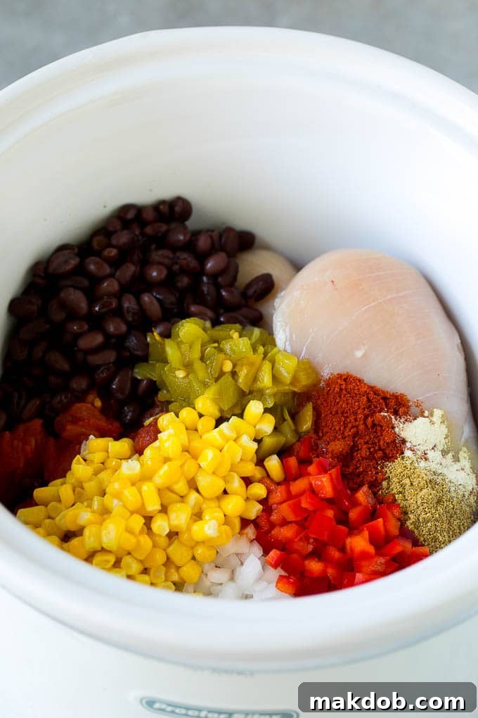Chicken breasts with vegetables and spices in a crock pot.