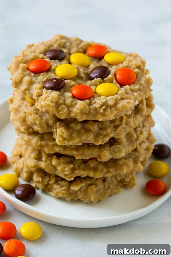 Stack of Delicious No-Bake Peanut Butter Oatmeal Cookies A beautifully arranged plate featuring a stack of three no-bake peanut butter cookies, each showing its chewy texture and colorful candy topping.
