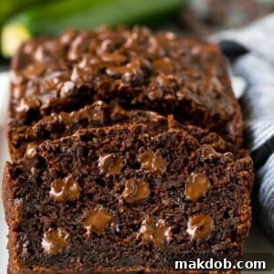 A tempting slice of chocolate zucchini bread, rich with cocoa and brimming with melted chocolate chips.