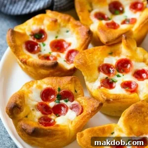 A plate of golden-baked pizza muffins, made with flaky crescent roll dough, savory pizza sauce, melted cheese, and mini pepperoni.