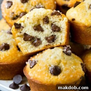 A cross-section of a tender chocolate chip muffin, revealing plenty of melted chocolate chips inside.