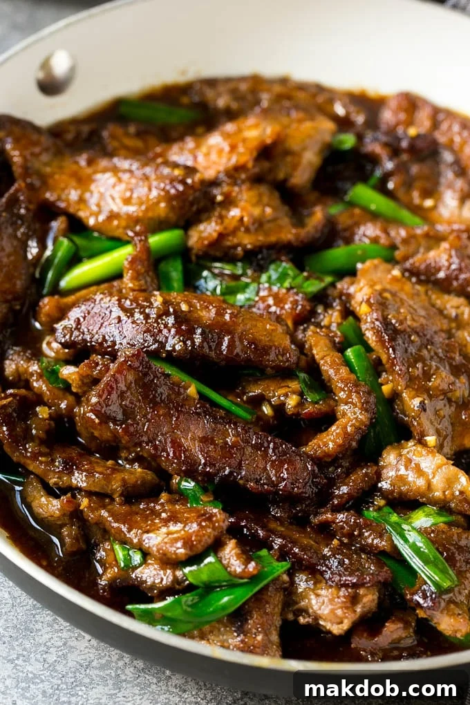 Mongolian Beef Recipe | Asian Beef Recipe | Chinese Beef | Beef Stir Fry #Chinese #Mongolian #Asian #mongolianbeef #beef #dinneratthezoo #dinner A pan full of Mongolian beef, vibrant with green onions, ready to serve.