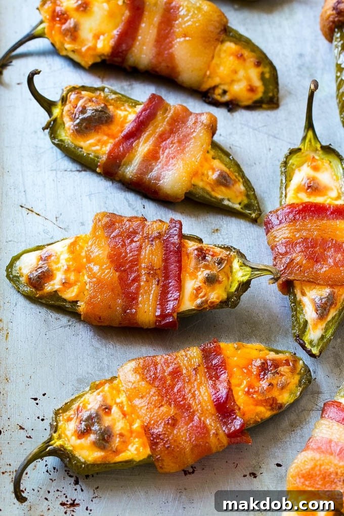 A sheet pan with bacon wrapped jalapeno poppers.