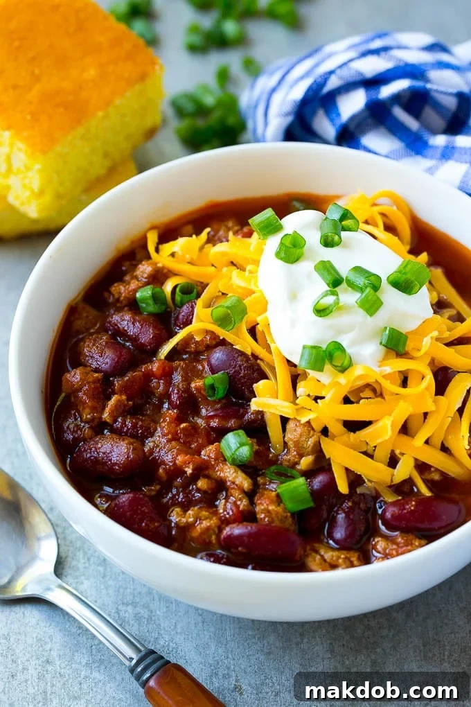 Hearty Slow Cooker Turkey Chili 2 A bowl of slow cooker turkey chili topped with sour cream and cheese.