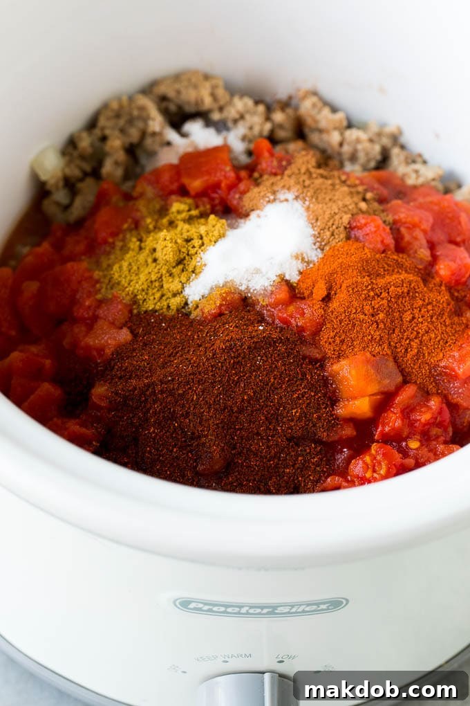 Hearty Slow Cooker Turkey Chili 4 Turkey, tomatoes and a blend of spices simmering in a crockpot.