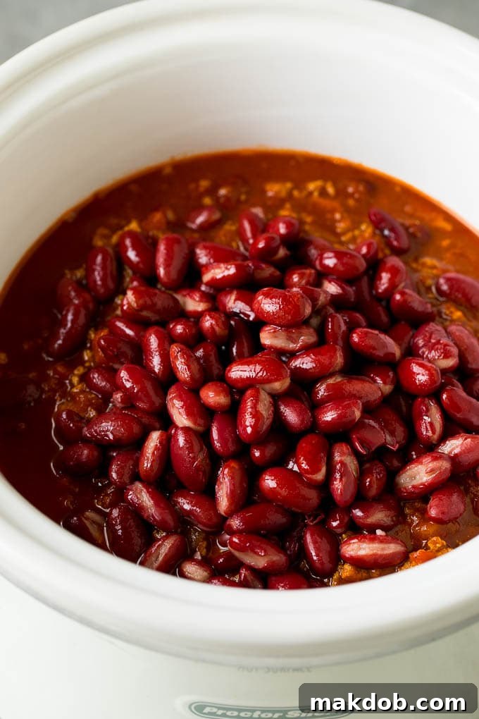 Hearty Slow Cooker Turkey Chili 5 Kidney beans added to the chili in a slow cooker, nearing completion.