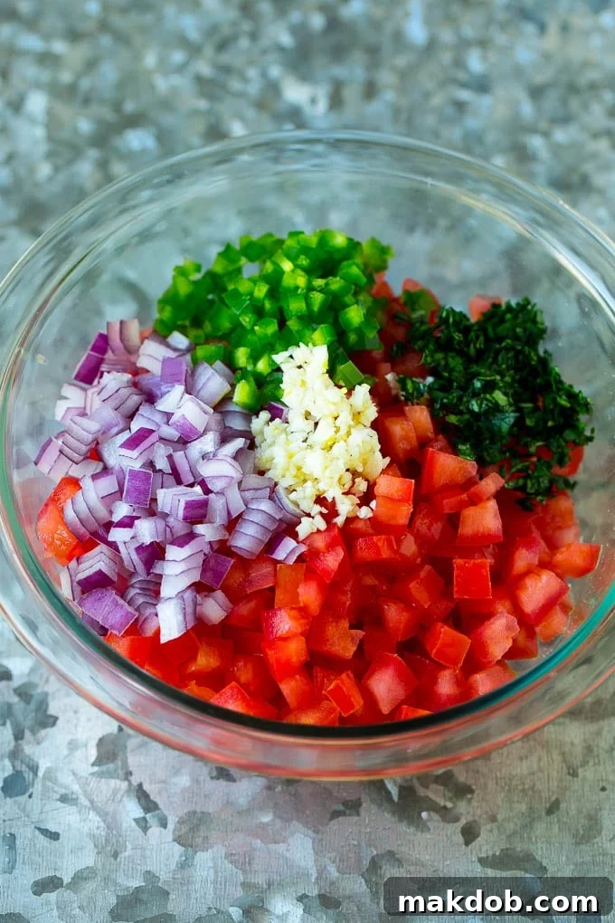 Vibrant Homemade Pico de Gallo 4 A colorful array of diced tomatoes, finely chopped red onion, minced garlic, a fresh jalapeño, and fragrant cilantro leaves in a single bowl, showcasing the raw ingredients of pico de gallo.