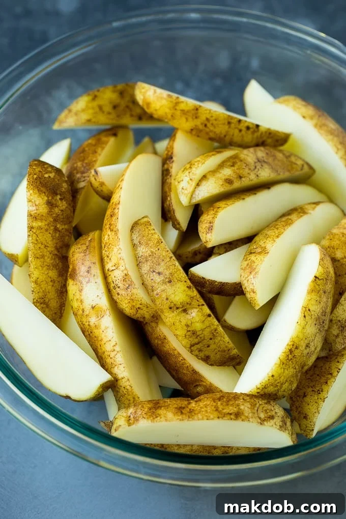 A bowl of potatoes cut into wedges.