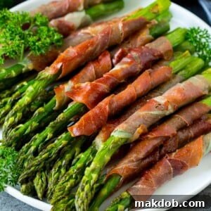 A plate of prosciutto wrapped asparagus garnished with fresh parsley.