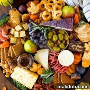 A Thanksgiving charcuterie board made with meats, cheeses, crackers, fruit and fall themed sweets.