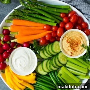 A large veggie tray with assorted fresh and steamed vegetables, ranch dip and hummus.