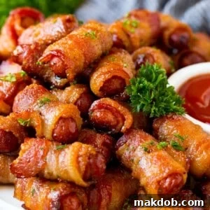 A serving plate of bacon wrapped smokies with parsley and a side of ketchup.