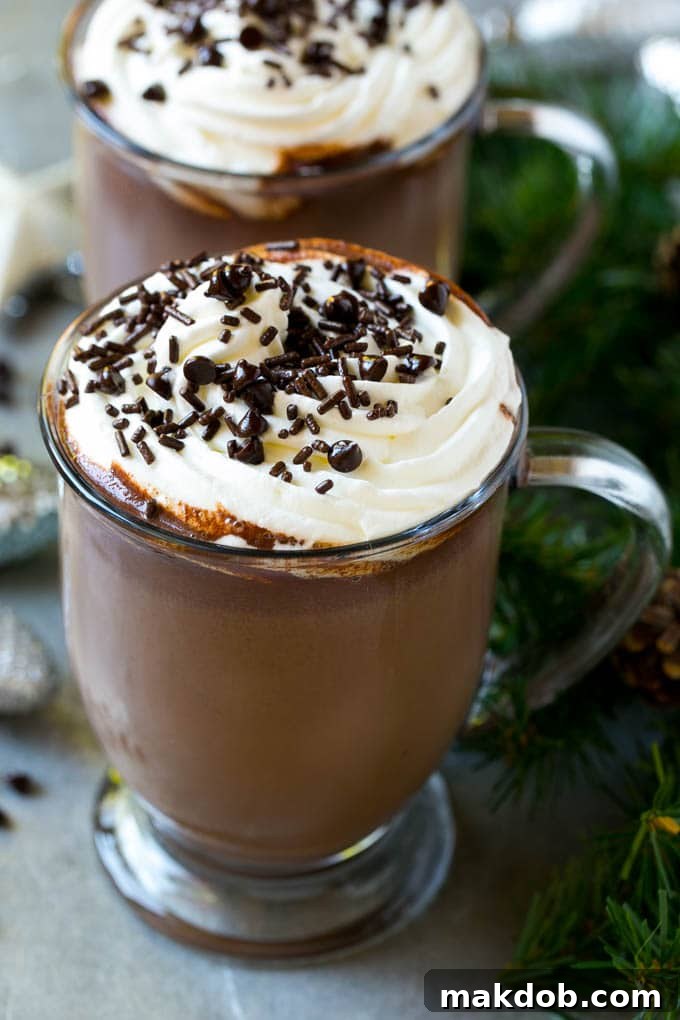 Slow Cooker Hot Chocolate Recipe | Homemade Hot Chocolate | Slow Cooker Hot Cocoa | Crock Pot Hot Chocolate #cocoa #hotchocolate #chocolate #slowcooker #crockpot #holiday #christmas #drink A cozy mug of crock pot hot cocoa generously topped with fluffy whipped cream, inviting you to take a sip.