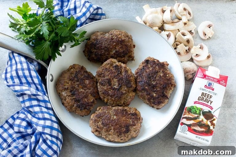 Slow Cooker Salisbury Steak Recipe | Homemade Salisbury Steak | Salisbury Steak from Scratch #steak #beef #salisbury #salisburysteak #slowcooker #crockpot #dinner #dinneratthezoo Hamburger patties browned in a skillet.